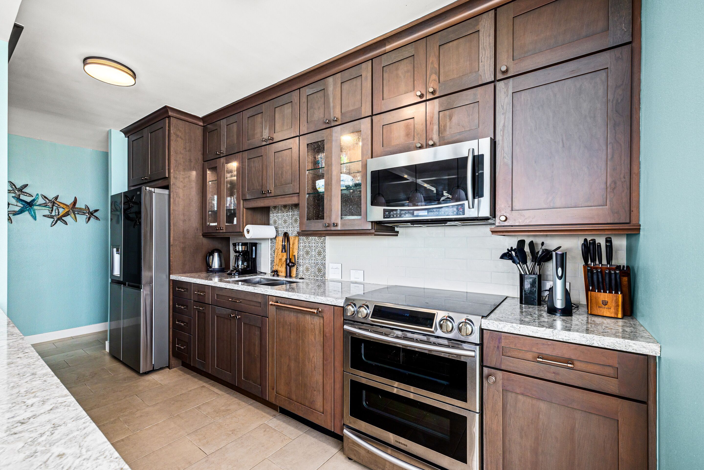 A kitchen with wooden cabinets, stainless steel appliances, and a tiled backsplash.