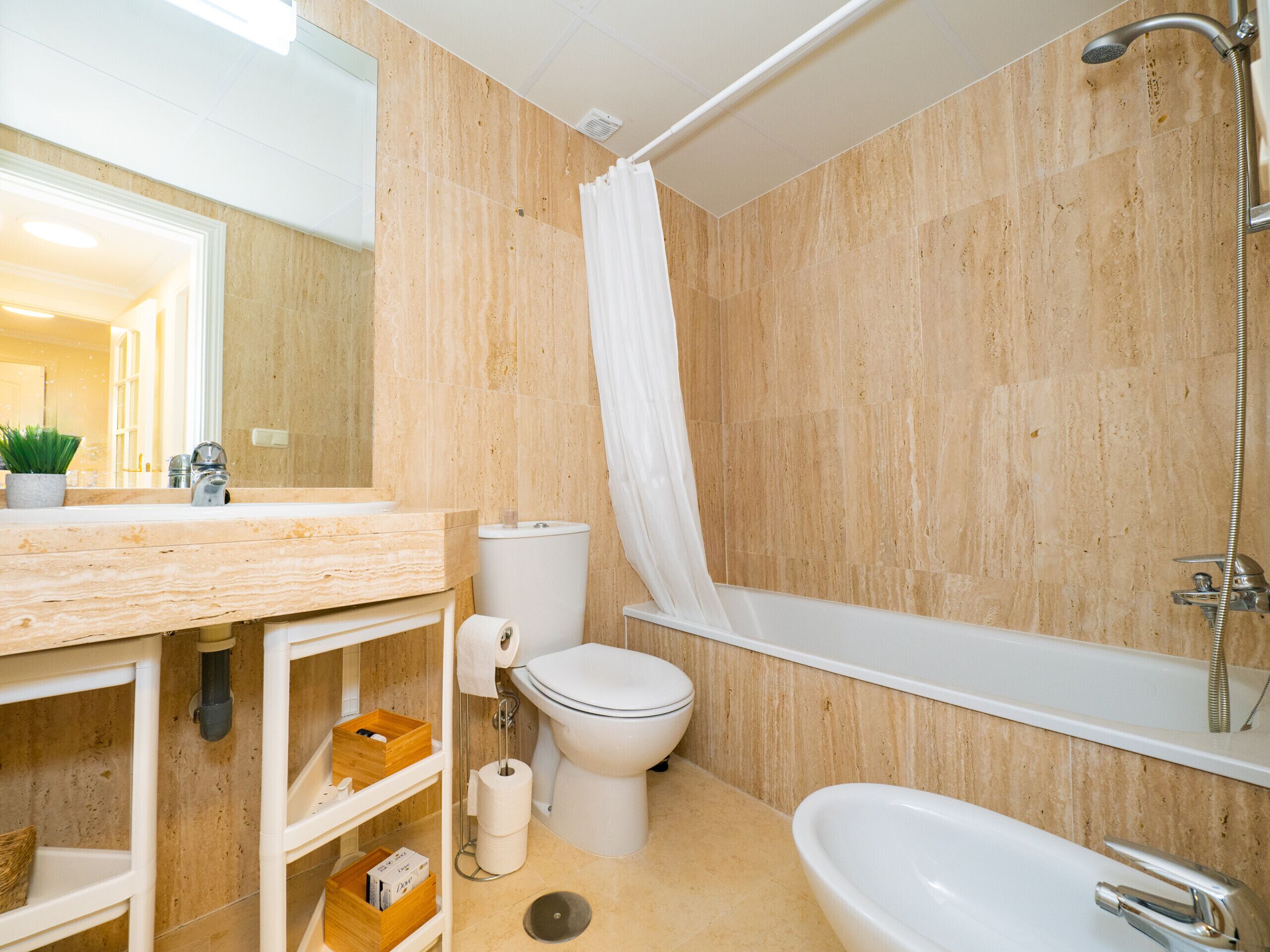 Une salle de bain moderne avec un meuble-lavabo en bois, des toilettes, une baignoire et une douche.
