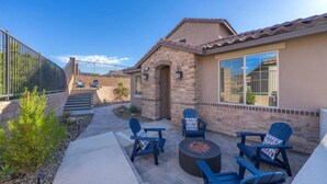 A residential property with a patio area featuring outdoor seating and a fire pit. - End of Summer Golf Getaway | PGA West | Golf Cart (La Quinta)