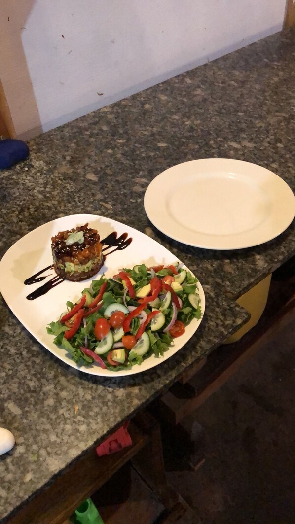 Un plato de sushi y una ensalada sobre una encimera de cocina.