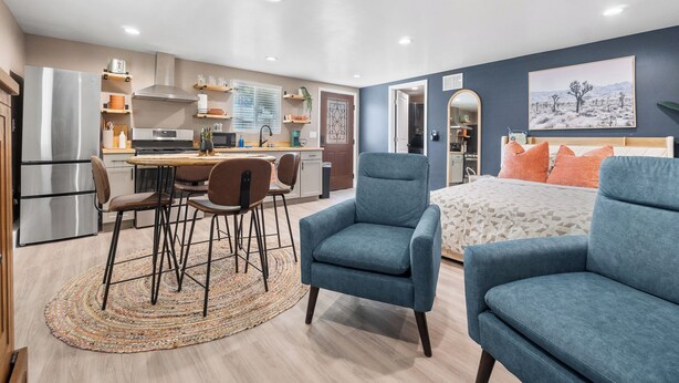 Un appartement moderne comprenant une cuisine, un coin repas et une chambre.