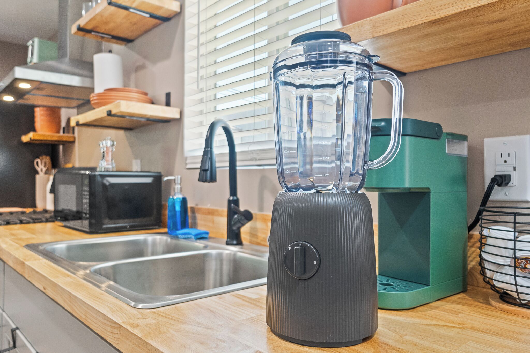 A kitchen with a blender, a toaster, and a coffee maker on the counter.