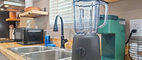A kitchen with a blender, a toaster, and a coffee maker on the counter.