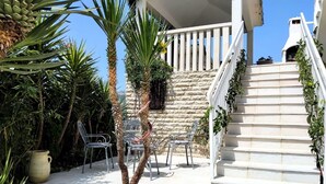 A stone staircase leading to a white balcony with metal chairs and a potted plant. - Villa Marija - Five Bedroom Villa with Terrace and Swimming Pool (Podstrana)