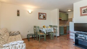 Un espacio habitable compacto con comedor, kitchenette y sofá.