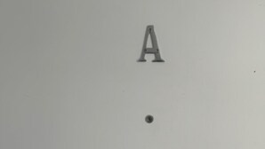 Un muro spoglio con una singola lettera 'A' e un punto.