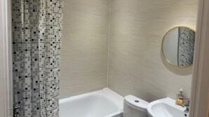 Un bagno con doccia, vasca, water e lavandino.