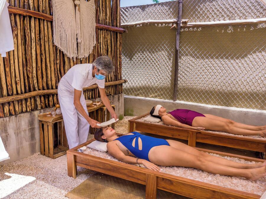 A traditional spa setting with wooden benches and a bamboo backdrop.