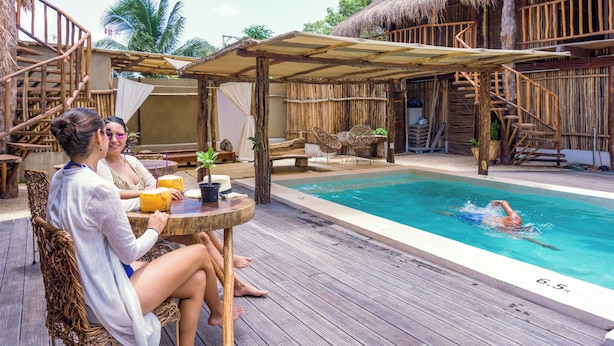 A wooden deck with a pool, a covered seating area, and a thatched-roof structure. - Jungla & Estrellas (Coba)