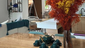Une cuisine moderne avec un coin repas, un fauteuil suspendu et un vase de fleurs.