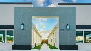 Une entrée moderne, avec un chemin dégagé menant à une porte portant le numéro 3512.