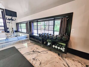 Ein Fitnessraum mit Trainingsgeräten und Kurzhanteln.