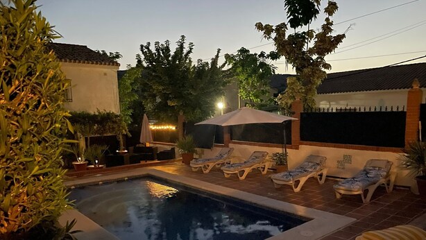 A rectangular swimming pool with a tiled border, surrounded by lounge chairs and potted plants. - Lovely 10-bed Villa With Private Pool & Garden (Cacin)