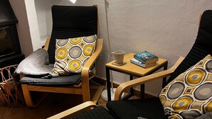 A cozy room with two wooden chairs, one with a patterned cushion and the other with a solid cushion. A small wooden table holds a book and a cup. - Lovely 10-bed Villa With Private Pool & Garden (Cacin)