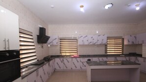 Een moderne keuken met witte kasten, een centraal kookeiland en ingebouwde apparatuur.