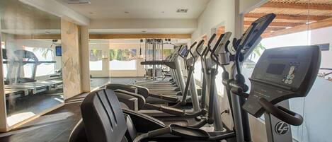 Ein Fitnessstudio mit mehreren Laufbändern und Trainingsgeräten.
