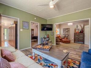 A living room with a sofa, a coffee table, a television, and a fireplace. - Fruita Finds: Dog Friendly Downtown Gem (Fruita)