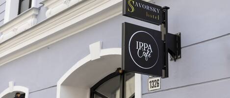 A building with a sign for 'SAVORSKY hotel' and 'IPPA Café'.
