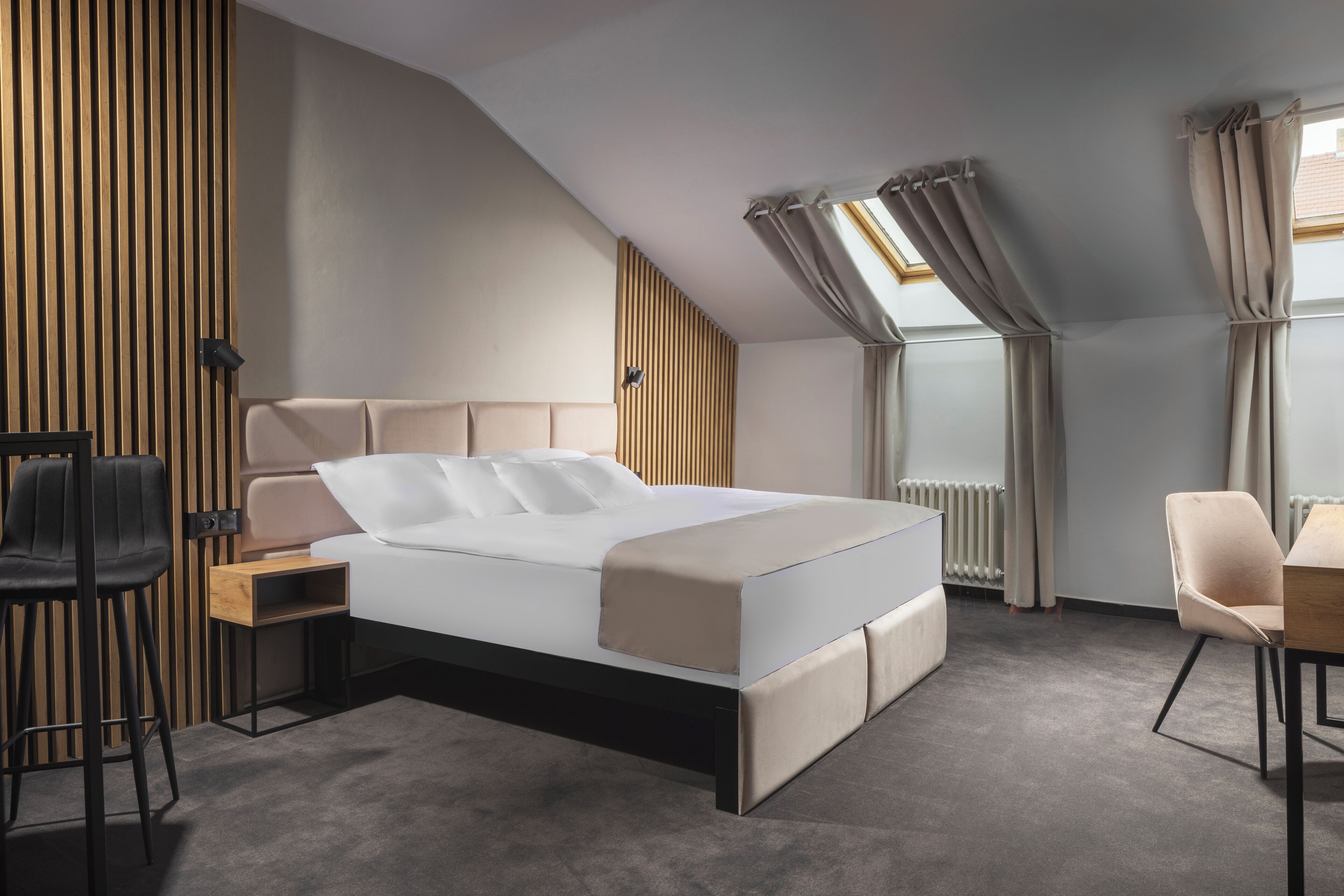 Una camera da letto moderna con un letto, una scrivania, una sedia e un termosifone.