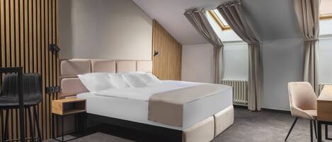 A modern bedroom with a bed, a desk, a chair, and a radiator.