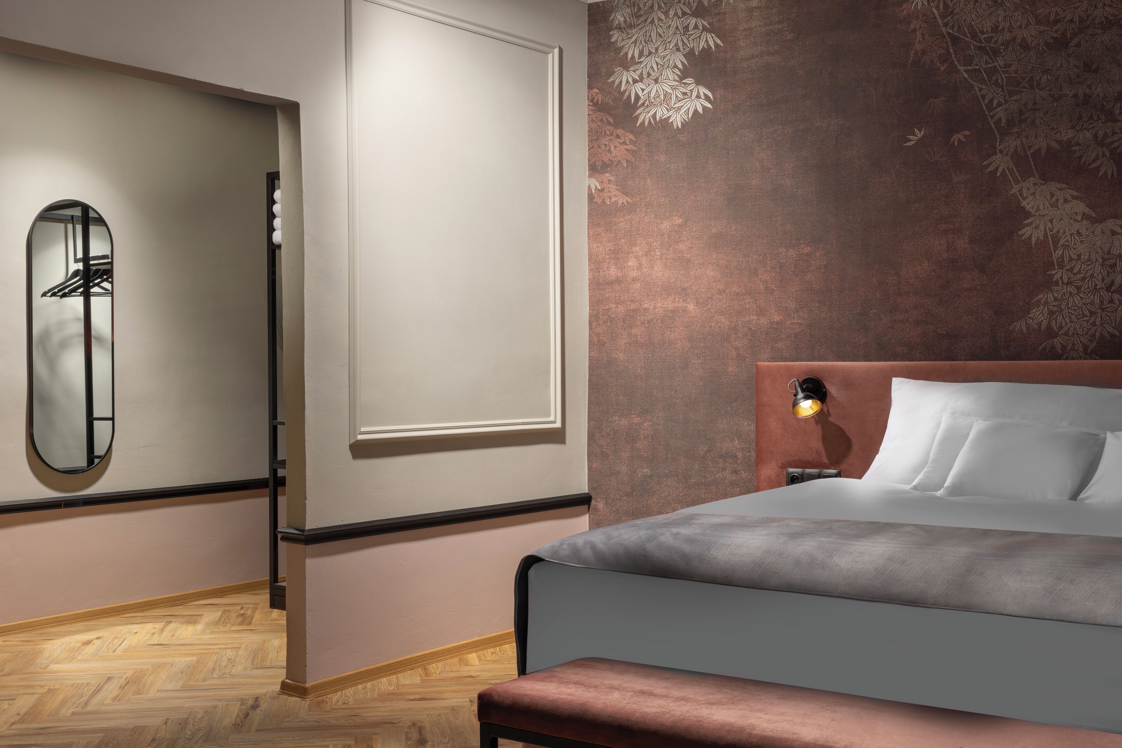 Ein Schlafzimmer mit einem Bett, einem Nachttisch, einem Spiegel und einer Wand mit einer strukturierten Oberfläche.