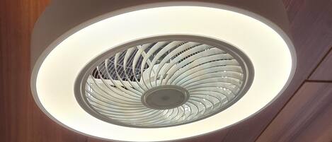 A ceiling with a circular light fixture and wooden paneling.