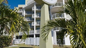 A hotel sign with the name "Crystal Palms Beach Resort" and a building with multiple balconies.