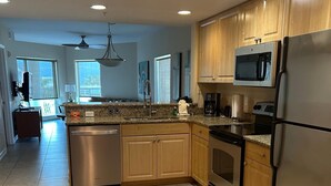 A modern kitchen with wooden cabinets, stainless steel appliances, and a large island.
