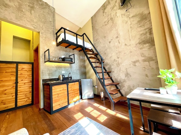 A modern kitchen with a wooden cabinet, a built-in oven, and a staircase leading to an upper level. - Colonia Suites 722 by Wellcome (Bogotá)