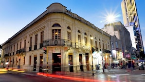 Ein historisches Gebäude mit klassischer Architektur, ausgestattet mit einem Balkon und mehreren Fenstern.
