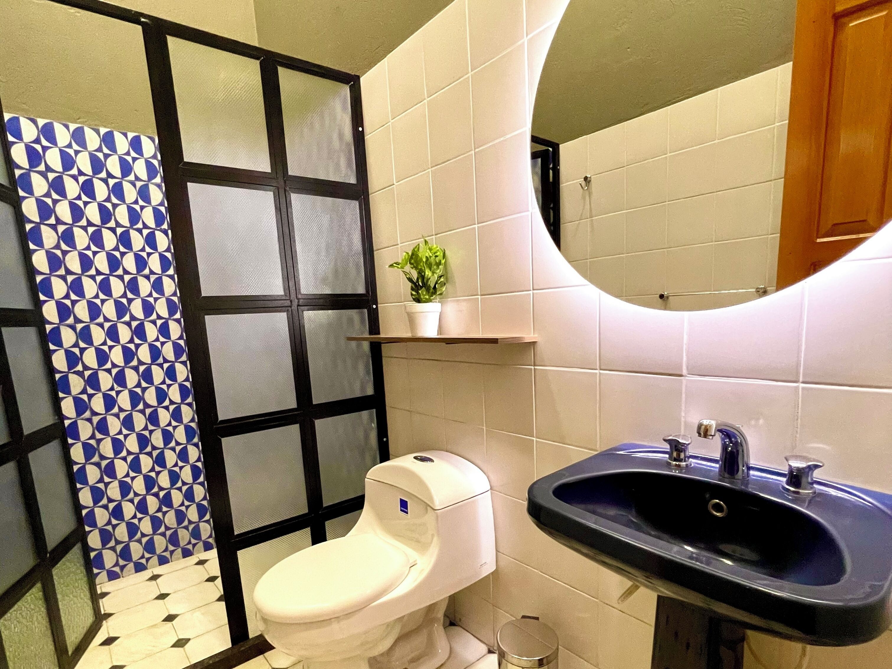 A bathroom with a toilet, sink, and a mirror.
