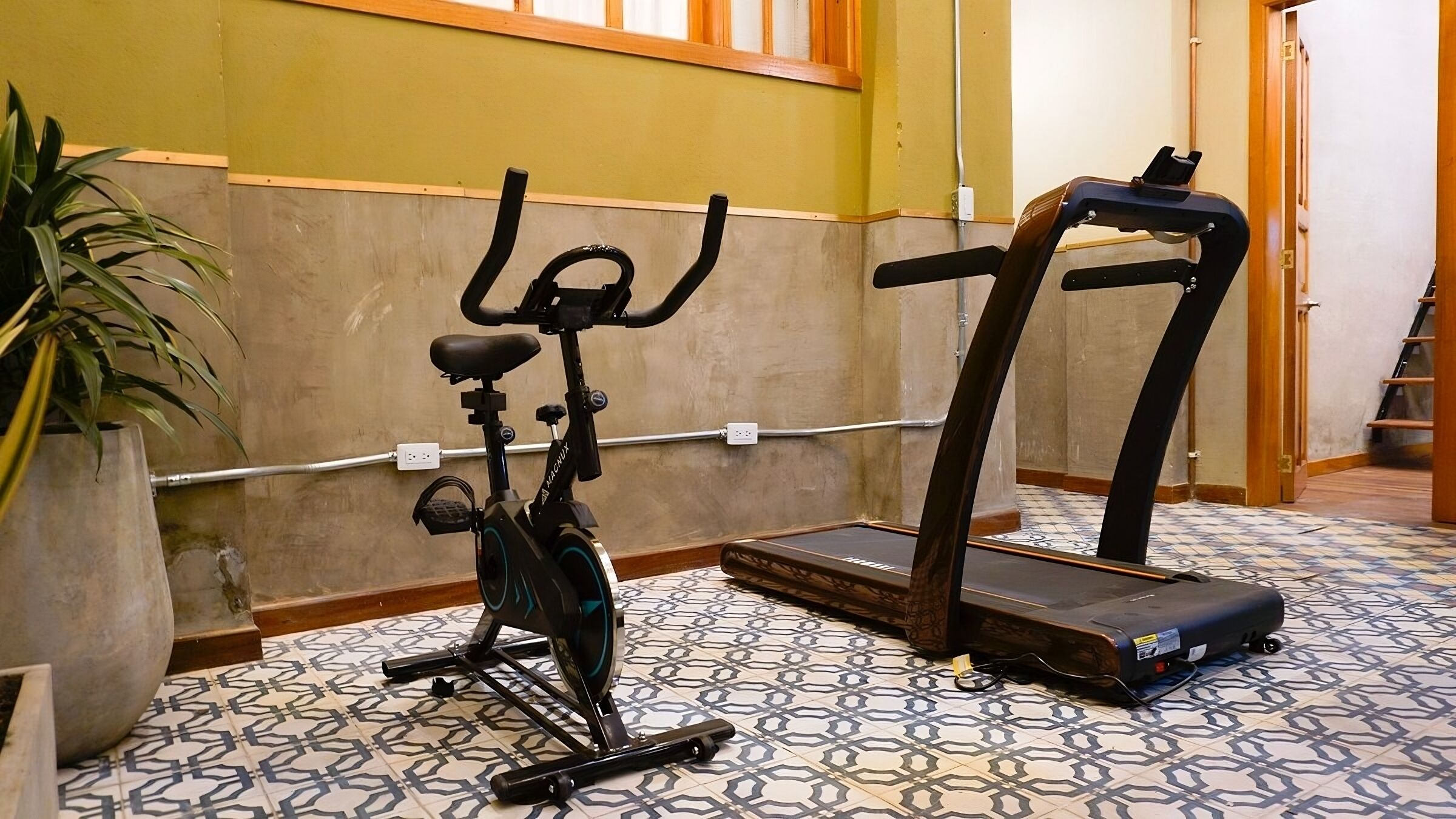 A room with a stationary bike and a treadmill.