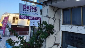 A building with a sign for Dafne Boutique Hotel, indicating it is a restaurant and cafe. - Dafne Butik Pansiyon (Karaburun)