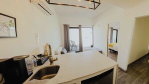 Una cocina moderna con un lavaplatos integrado, una cafetera y un comedor con mesa y sillas.
