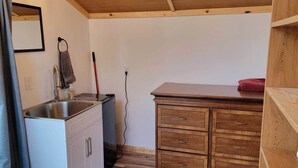 Eine kleine Küche mit Spüle, Schränken und einer Holzarbeitsplatte.