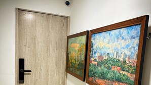 A hallway with a wooden door and two framed paintings on the wall. - Encantador Loft en Medellín (Medellin)