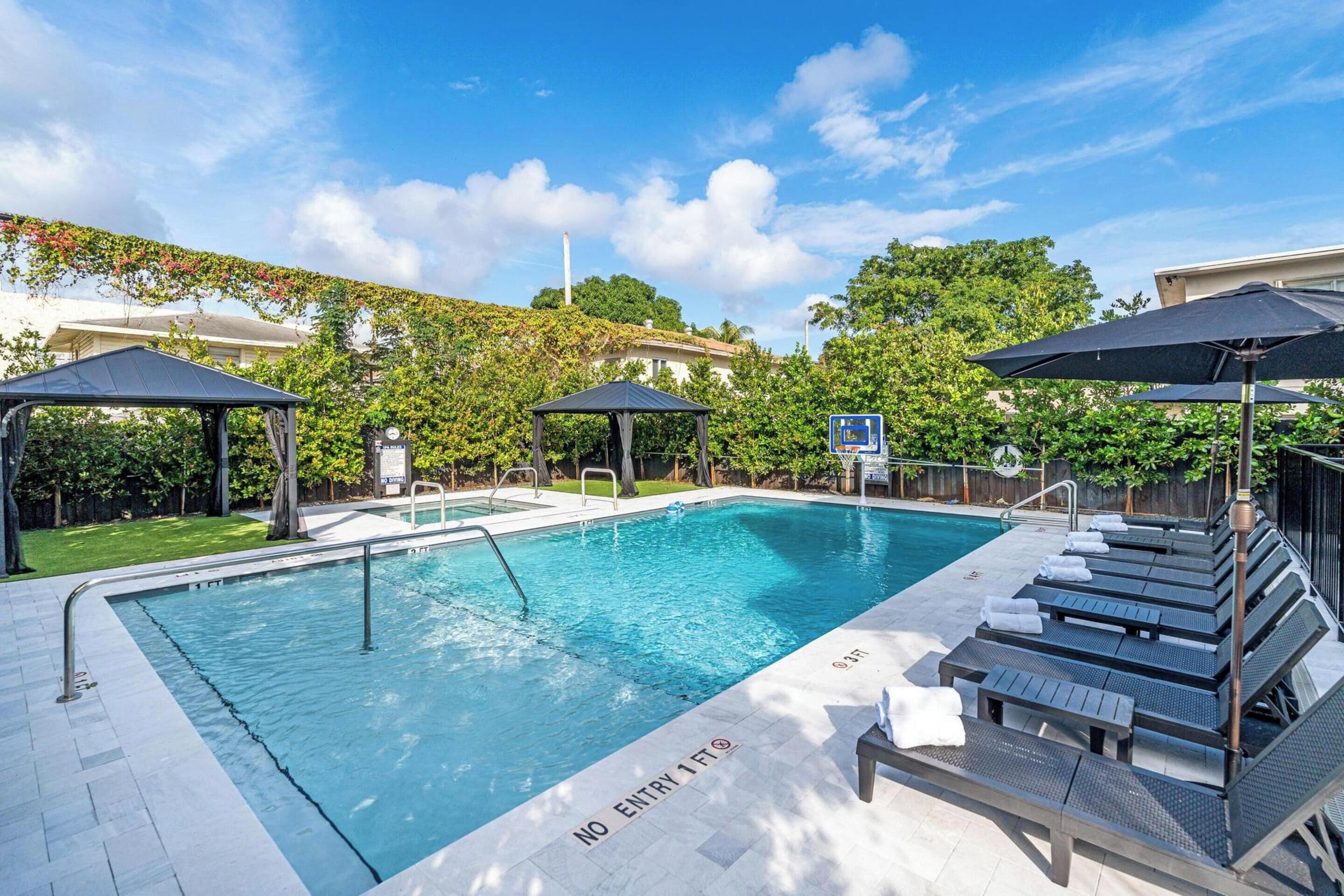 Utendørsbasseng,et oppvarmet basseng, bassengparasoller og solsenger