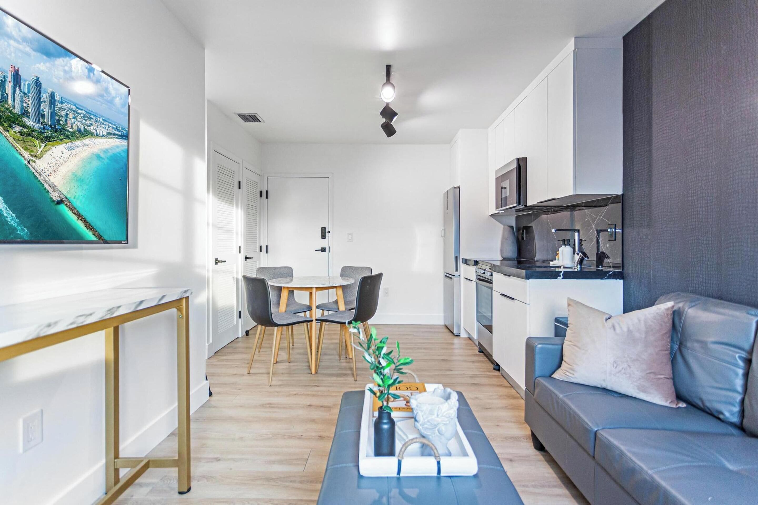 A modern living room with a sofa, a coffee table, and a dining area with chairs.