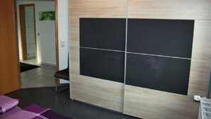 A room with a sliding door, a chair, and a small table.