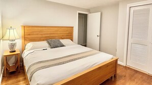 A bedroom with a wooden bed, a bedside lamp, and a wardrobe. - Charming 3-bedroom ranch 1 minute from Mohegan Sun. (Montville)