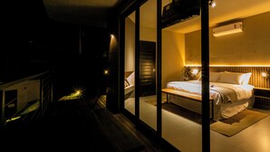 Un dormitorio moderno con una cama grande, una mesita de noche y un aire acondicionado instalado en la pared.