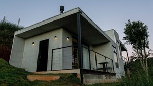 Una casa moderna con techo plano, un ventanal grande y un balcón.