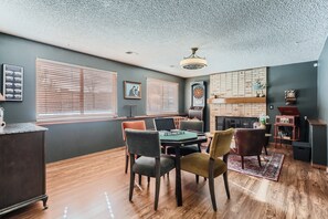 Enjoy a warm and inviting space with a dining area, fireplace, and large window.