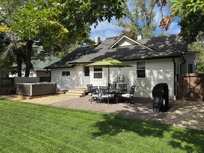 A house with a patio, a table with chairs, and a covered grill area. - Historic Home in Old Town Loveland (Loveland)