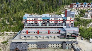 A multi-story hotel with a modern architectural design, featuring balconies and a ski lodge area. - Champagne Powder Chalet! Best Ski In/Out at Big White. Sleeps up to 7ppl. (Beaverdell)