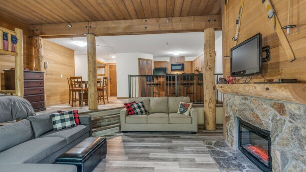 A cozy living room with a sofa, a fireplace, and a television. - Champagne Powder Chalet! Best Ski In/Out at Big White. Sleeps up to 7ppl. (Beaverdell)