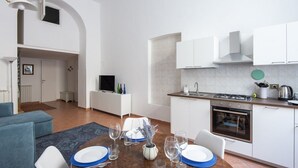 A modern kitchen with white cabinets, a stove, and a sink. - Vittorio Elegant Two Bedroom Apartment (Roma)