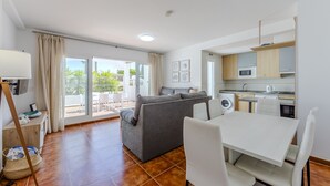 A compact living space with a sofa, dining table, and kitchenette. - AlmeriaSuite Mojacar Breeze Sun101 (Mojacar)