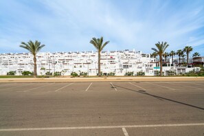 A parking lot with a row of white buildings in the background. - AlmeriaSuite Mojacar Breeze Sun108 (Mojacar)