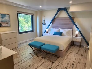 A bedroom with a bed, bedside tables, a window, and a desk. - The Sands (Sauble Beach)